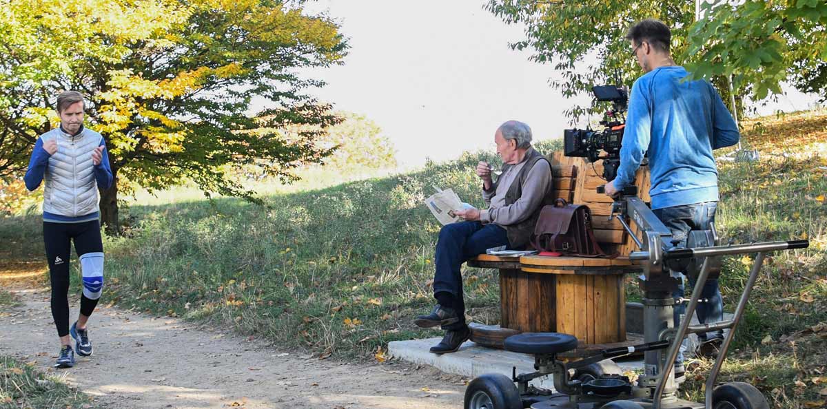 Der alte Mann beäugt argwöhnisch einen Jogger - Szene bei den Dreharbeiten zum Film Stille mit Michael Mendl und Thomas Jansen